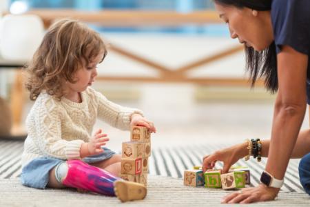 Therapist with little girl with prosthesis