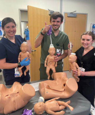 Residents facing the camera holding up plastic infants