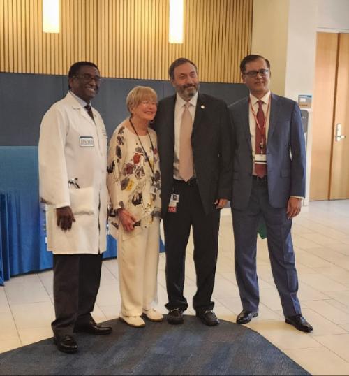 A photo of three doctors posing for a photograph with a woman