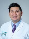 Jeffrey Woo, MD, smiles at the camera wearing his white coat.