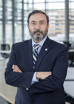 Dr. Alfred Z. Abuhamad standing in front of a modern building looking confident